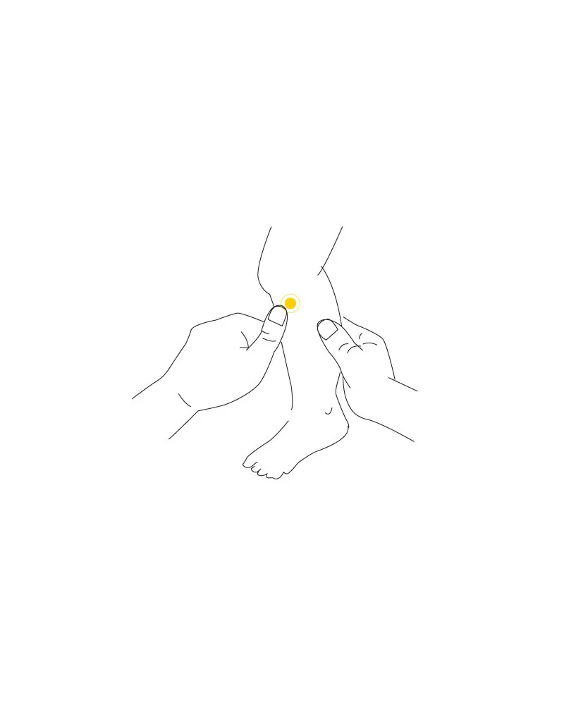 Adult hand locating Zu San Li ST36 on a child's lower leg