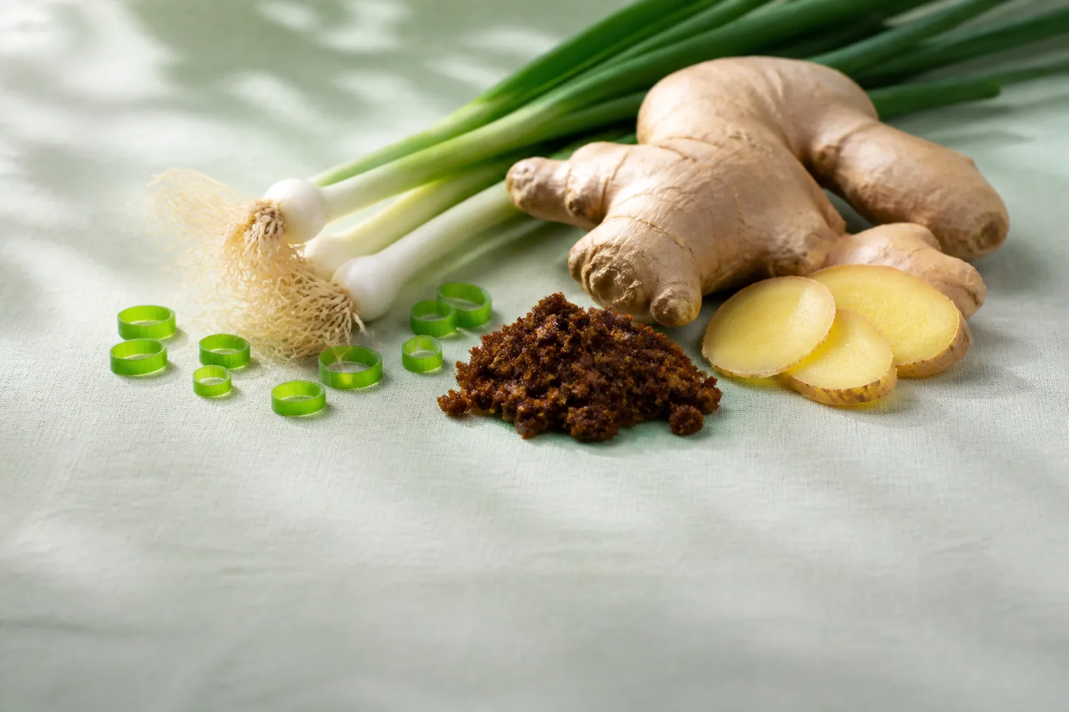 Fresh spring onion, ginger slices, and dark brown sugar for tea at PULSE TCM