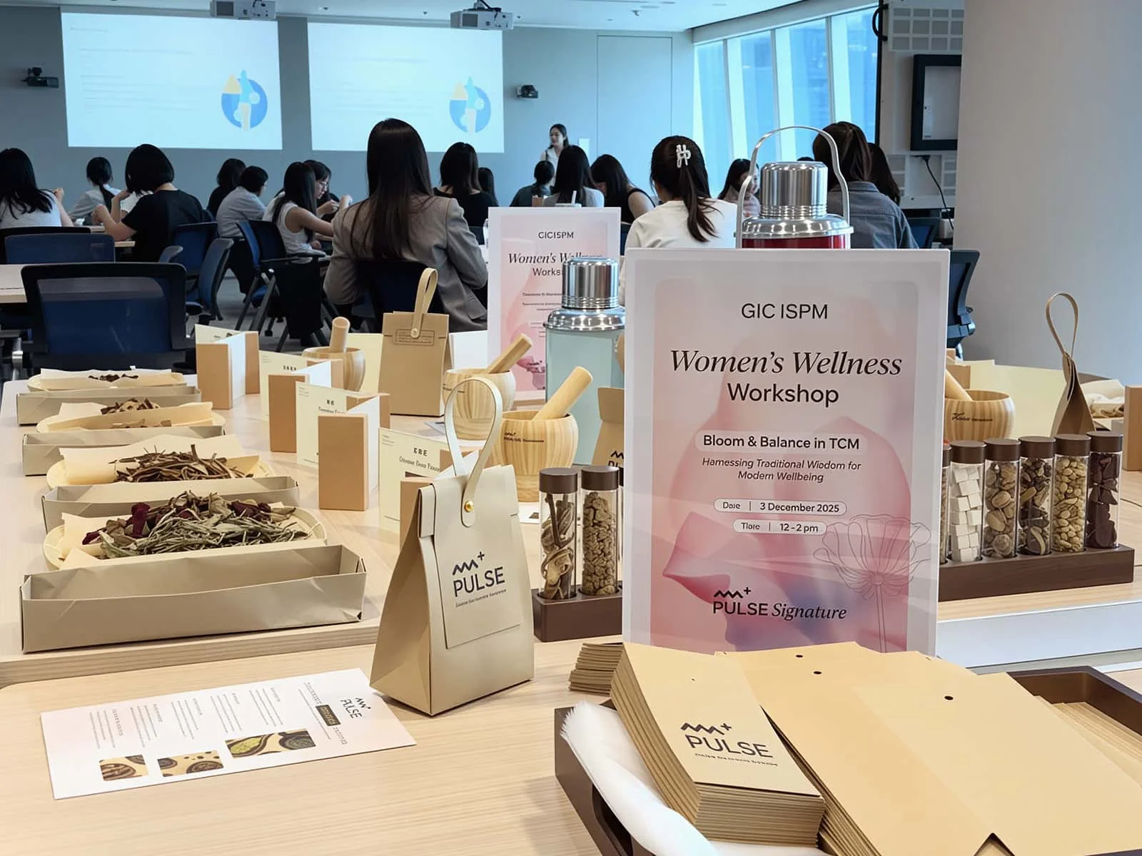 Women participating in a wellness workshop making herbal tea and learning about auricular therapy.