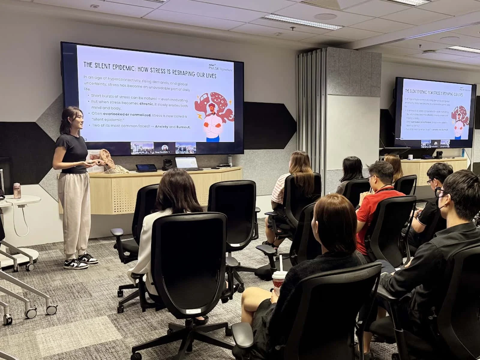Participants engaging in a wellness workshop at Toyota Motor Asia, practicing TCM exercises.