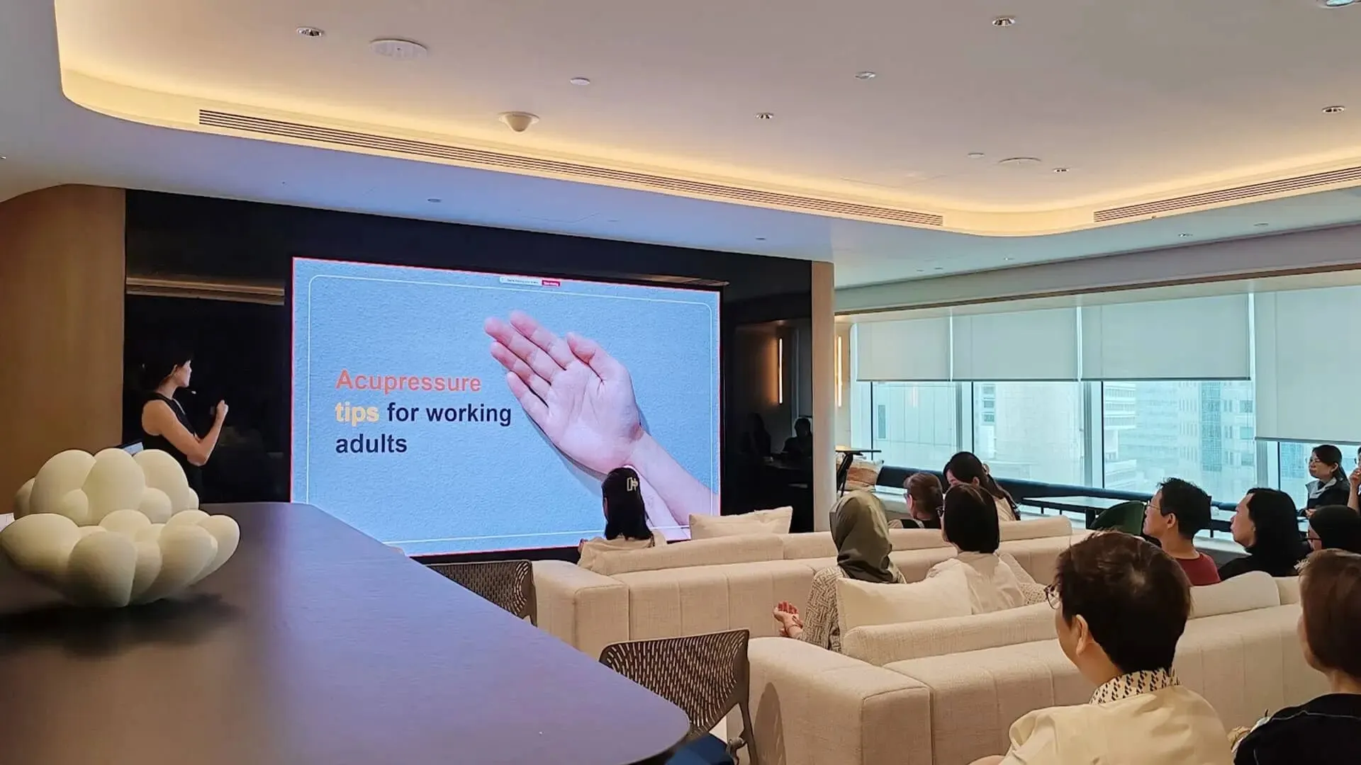Physician presenting TCM acupressure tips to a corporate audience