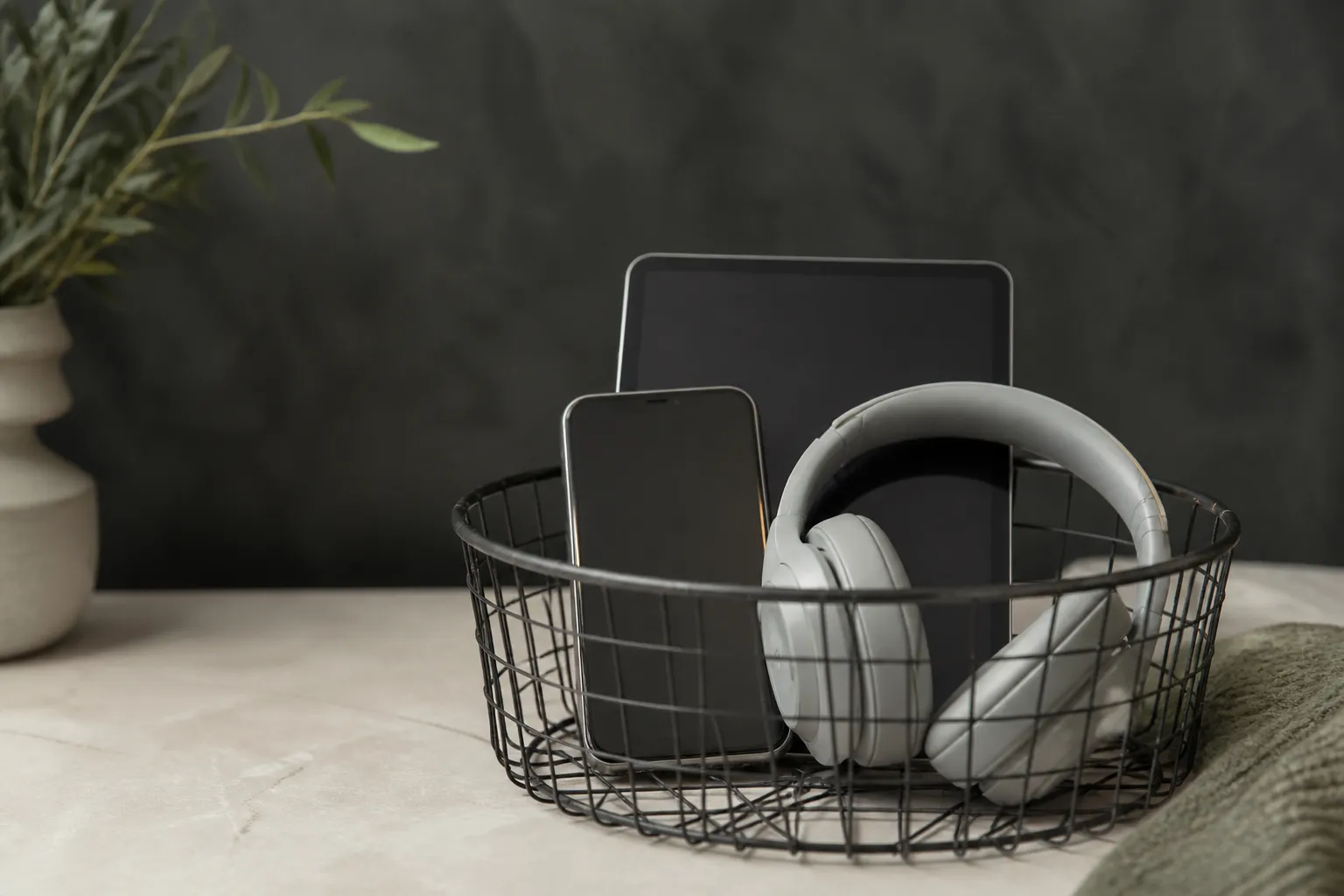 Wire basket holding phone, tablet, and headphones for a daily digital unplug