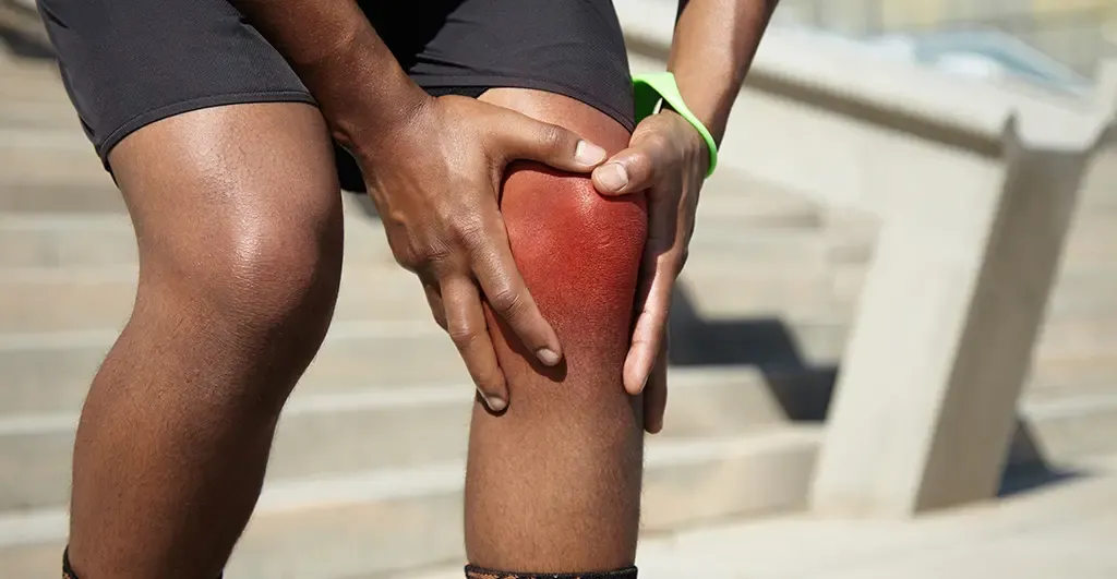 Hands holding a painful knee