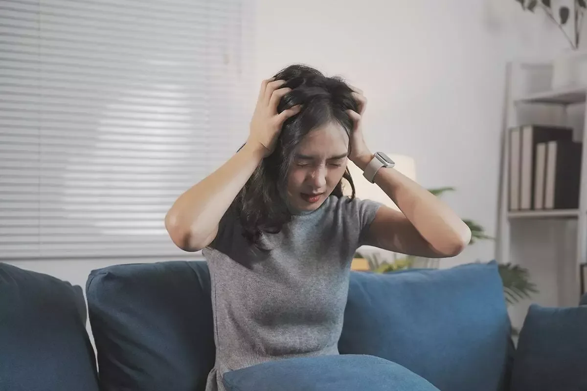 Woman holding her temples with premenstrual irritability