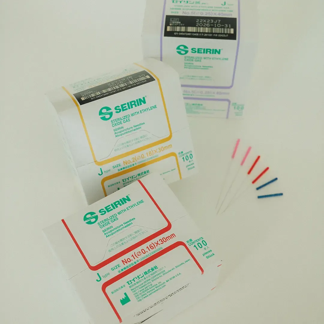 Seirin J-Type acupuncture needle boxes and colour-coded handles on a white surface