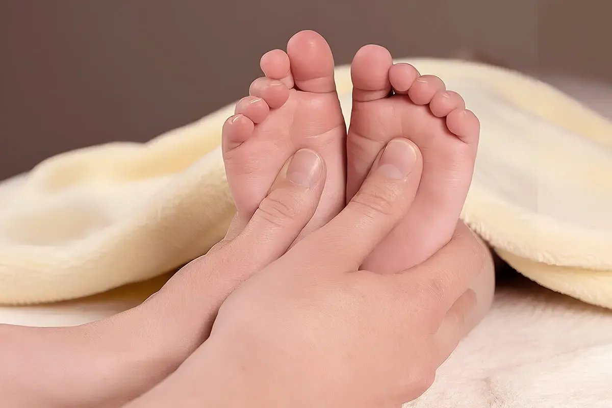 Gentle paediatric Tuina on a child's lower legs and feet