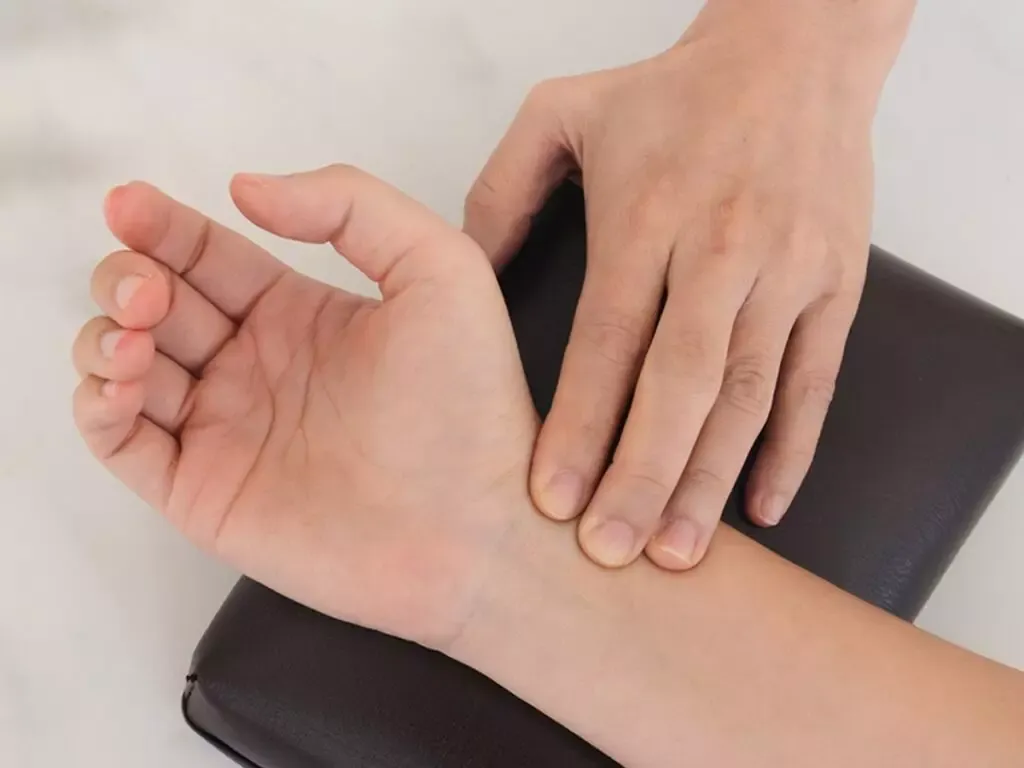Physician taking radial pulse during a TCM consultation